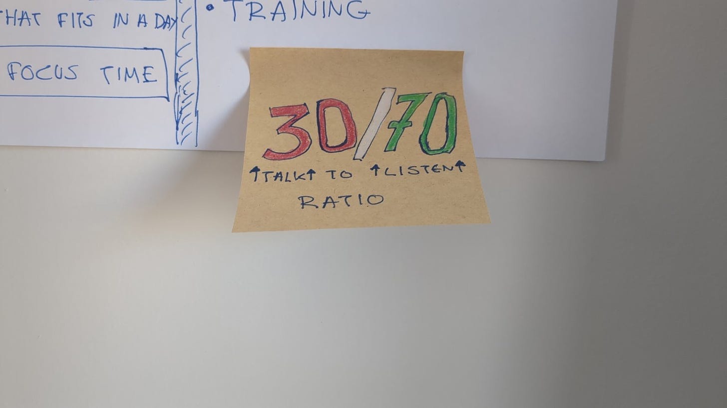Sticky note on wall reading “30/70, talk to listen ratio”
