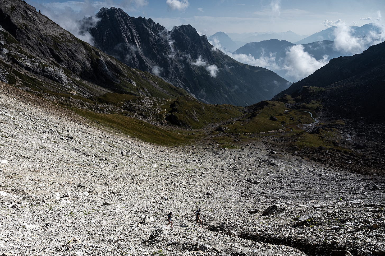 Two runners running down a mountain valley