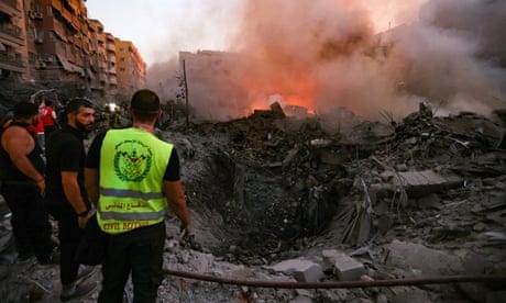 People gather near the smouldering remains of a destroyed building