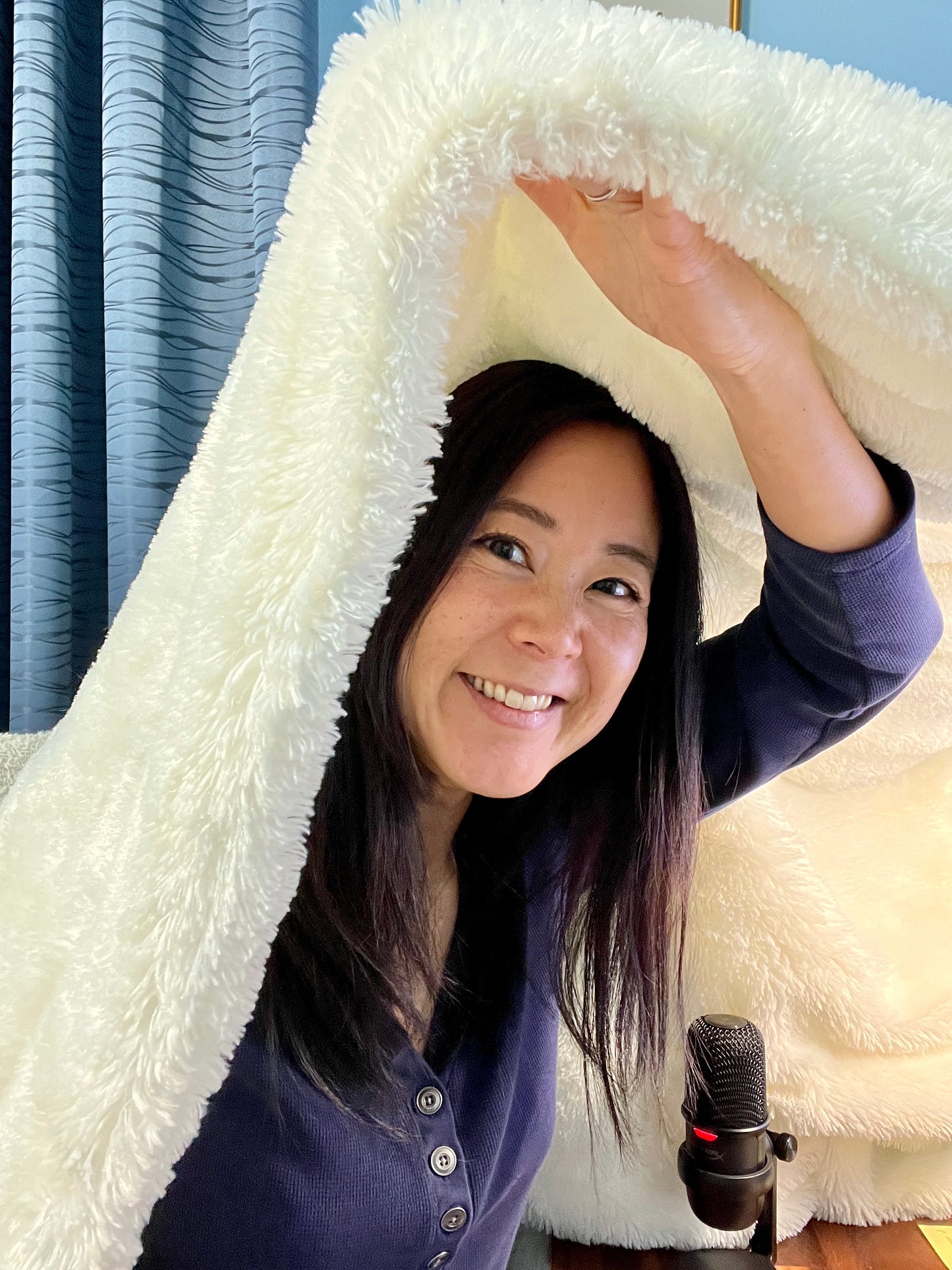 Author Evelyn Skye in her "recording studio," a blanket draped over her computer and microphone.