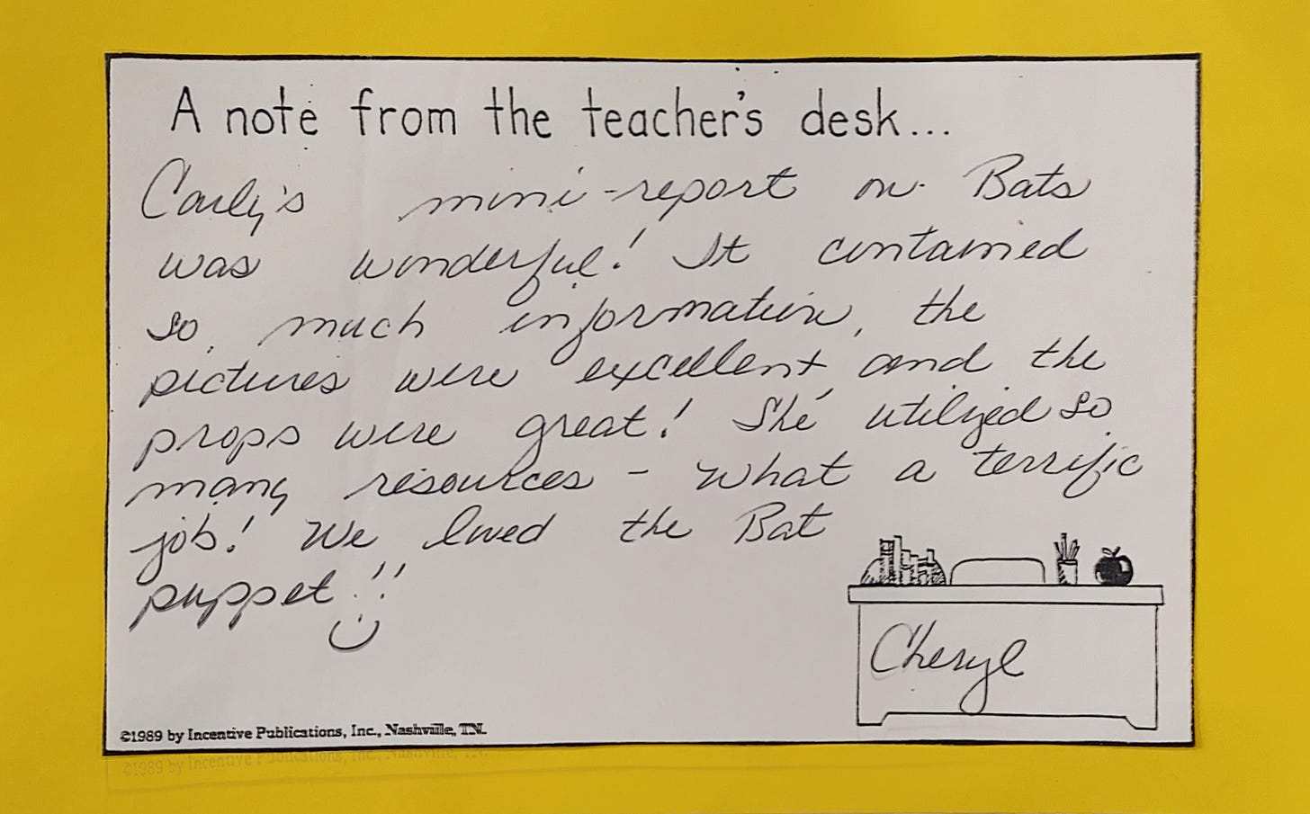 Note from a teacher, praising a student's report about bats. The note mentions the report's great use of information, pictures, and props. The teacher compliments the student on utilizing many resources and mentions how they loved the bat puppet.