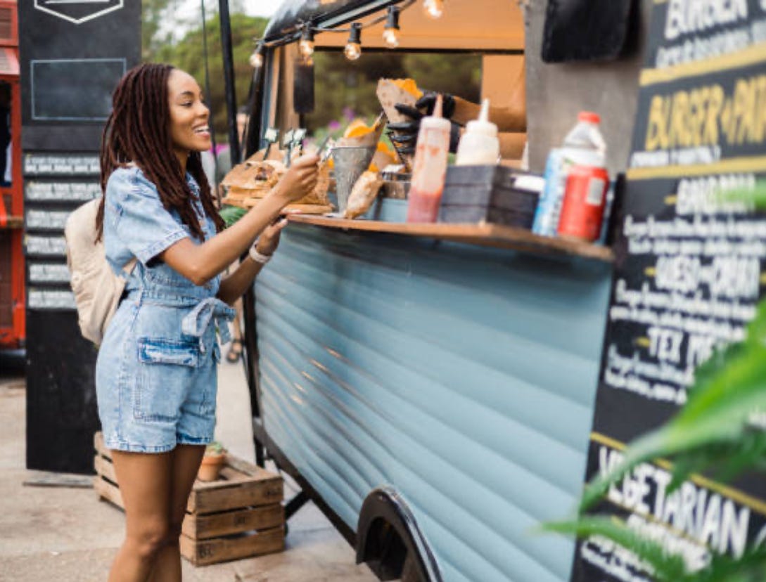 woman buying food at roach coach in Caribbean