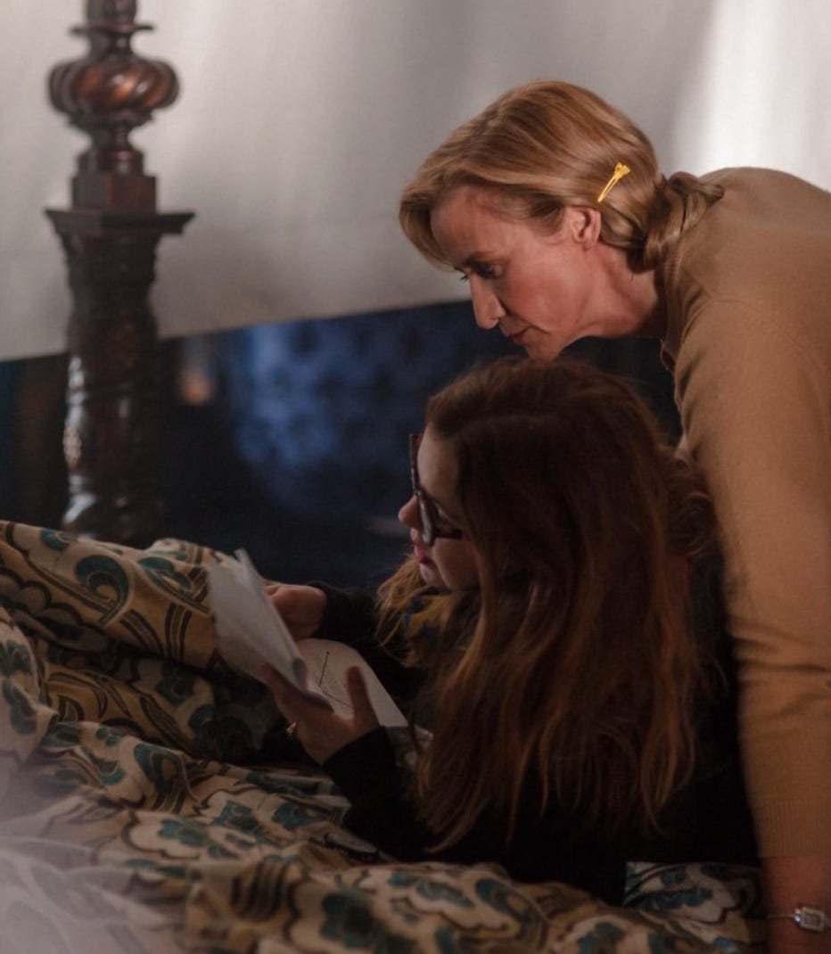 Amber Tamblyn and Janet McTeer lie on a bed on the set going over notes.
