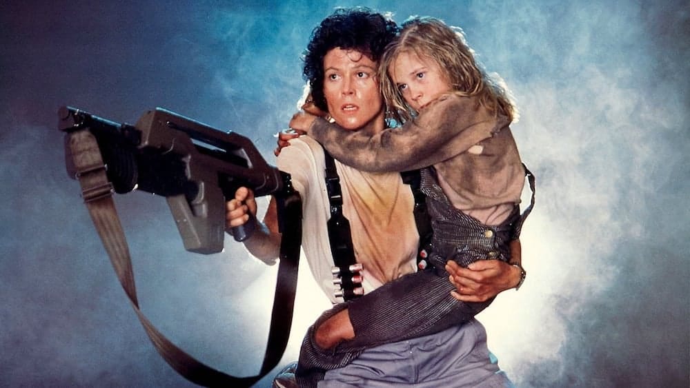 Sigourney Weaver is carrying a big gun and a young girl in this still from Aliens