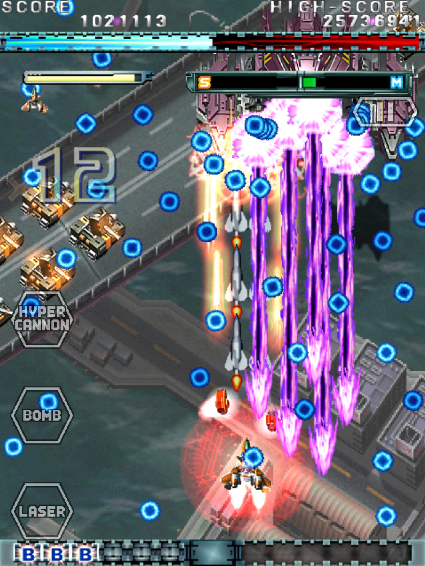 A scattering of blue bullets fills the screen, with tanks to the left
