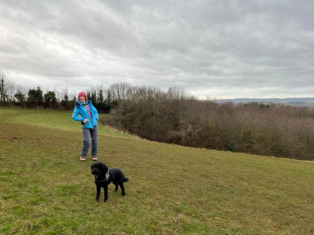 a woman and a dog on a hill