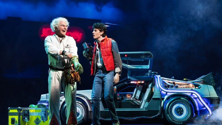Back to the Future: The Musical's Doc Brown (Roger Barts) and Marty McFly (Casey Likes) talking next to the DeLorean