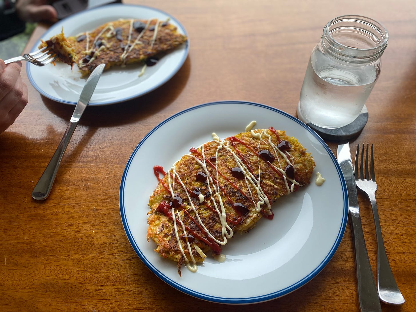 The cabbage pancake described above, oblong rather than round, drizzled with mayo, ketchup, and teriyaki sauce.