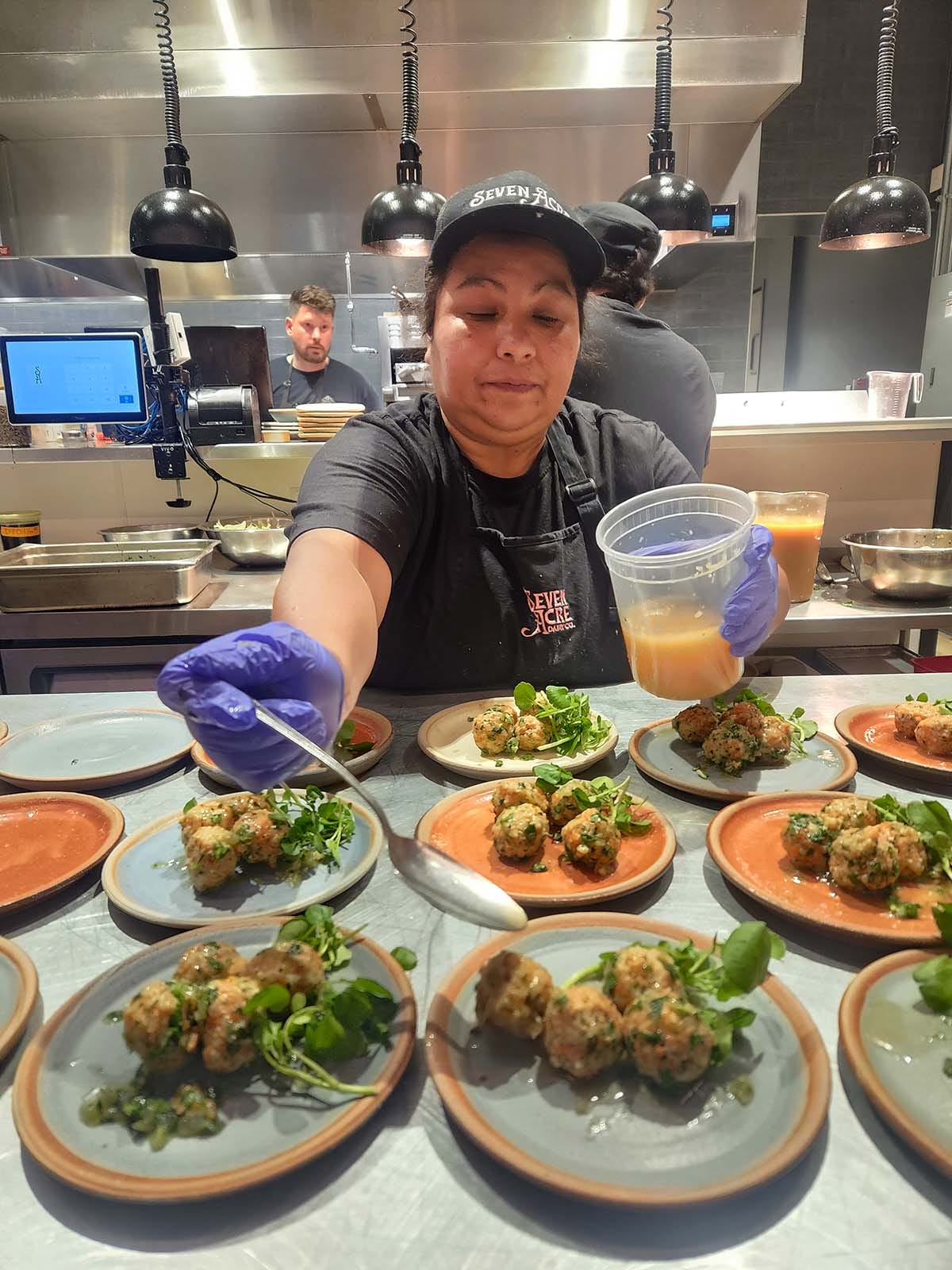 Ines saucing fish meatballs.