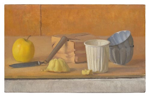 Objects resting on a wooden board, including two tin fluted molds, one tipped sideways inside the other. 