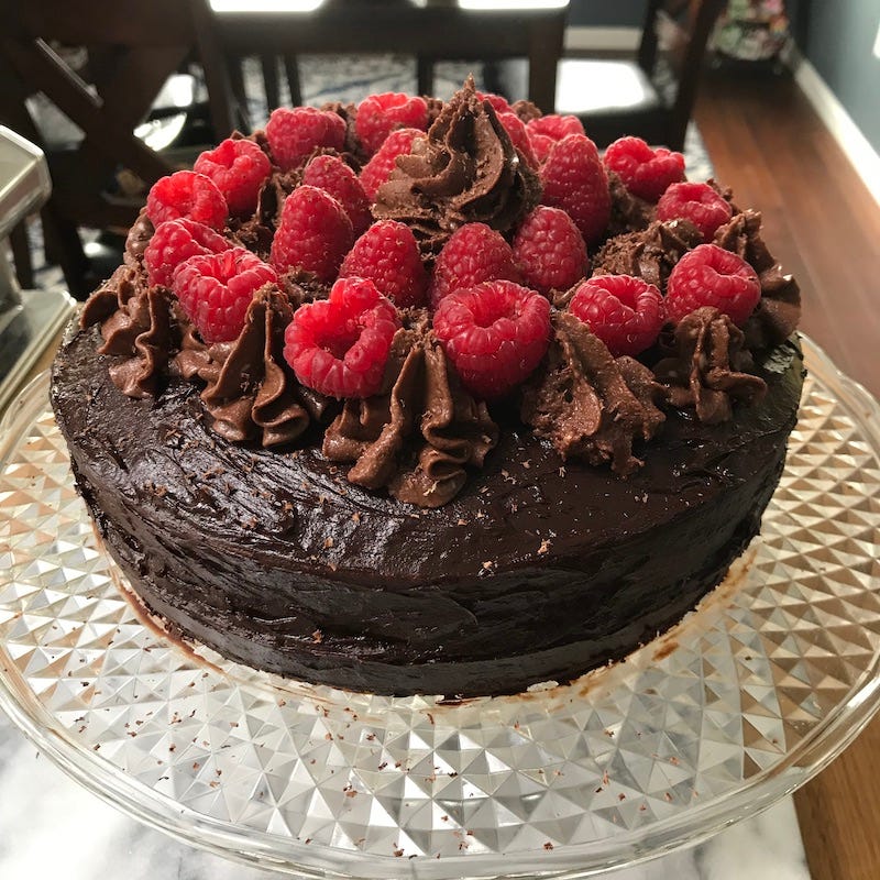 a chocolate cake topped with fresh raspberries