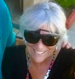 Head shot of Sherry Killam, Artist/Author, with white hair, dark glasses over an eye patch.