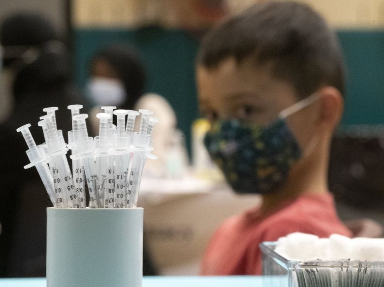 A student prepares to get his COVID-19 vaccination at Bailey Gatzert Elementary School in November in Seattle. (Ken Lambert / The Seattle Times)