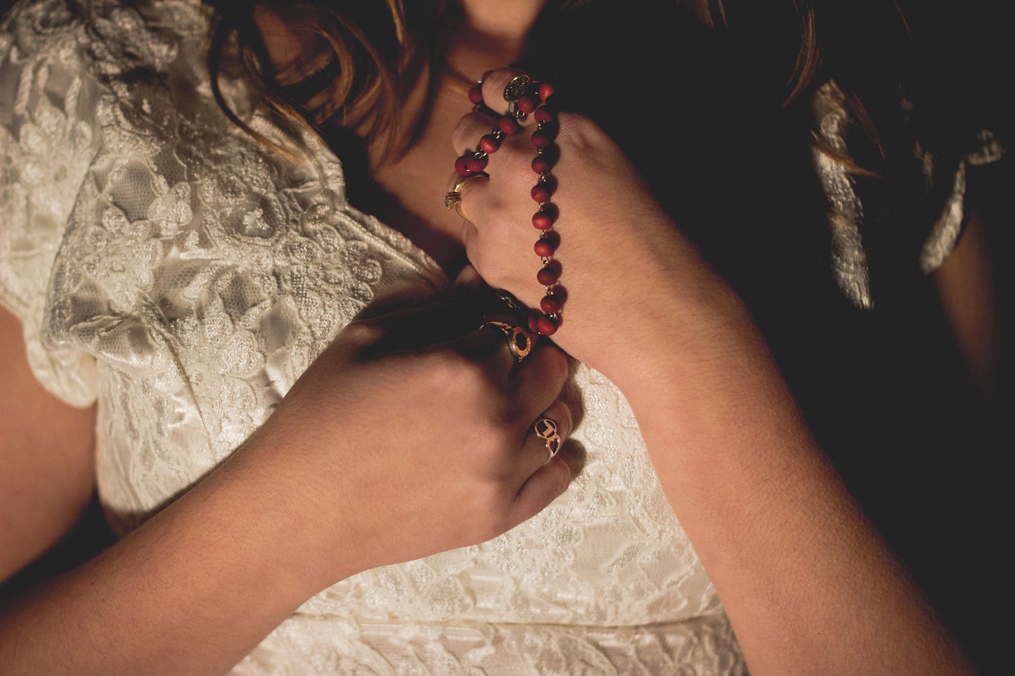 Woman in wedding dress holding rosary