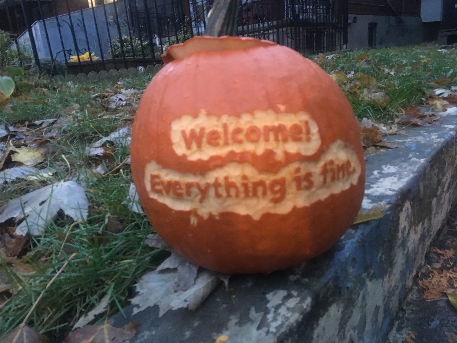 A Hallowe'en pumpkin carved with the words "Welcome! Everything is fine." It's not, though.