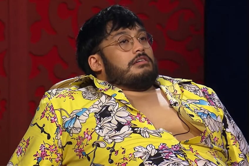 Comedian David Correos on Taskmaster New Zealand Season 2 in a yellow shirt with flowers