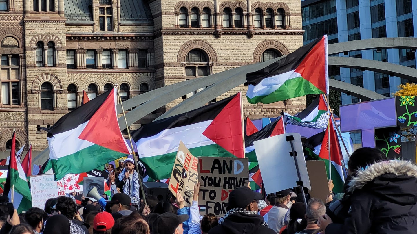 Palestine flags and signs in support of the country gather in Nathan Phillips Square in Toronto