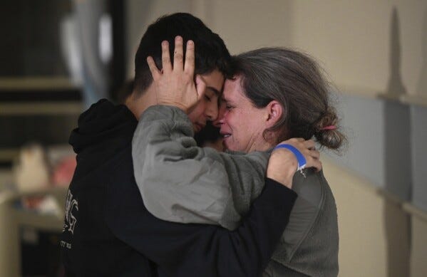En esta fotografía difundida por Haim Zach/GPO se ve a Sharon Hertzman, a la derecha, abrazando a un familiar después de reunirse en el Centro Médico Sheba, el sábado 25 de noviembre de 2023, en Ramat Gan, Israel. (Haim Zach/GPO/Handout via AP)