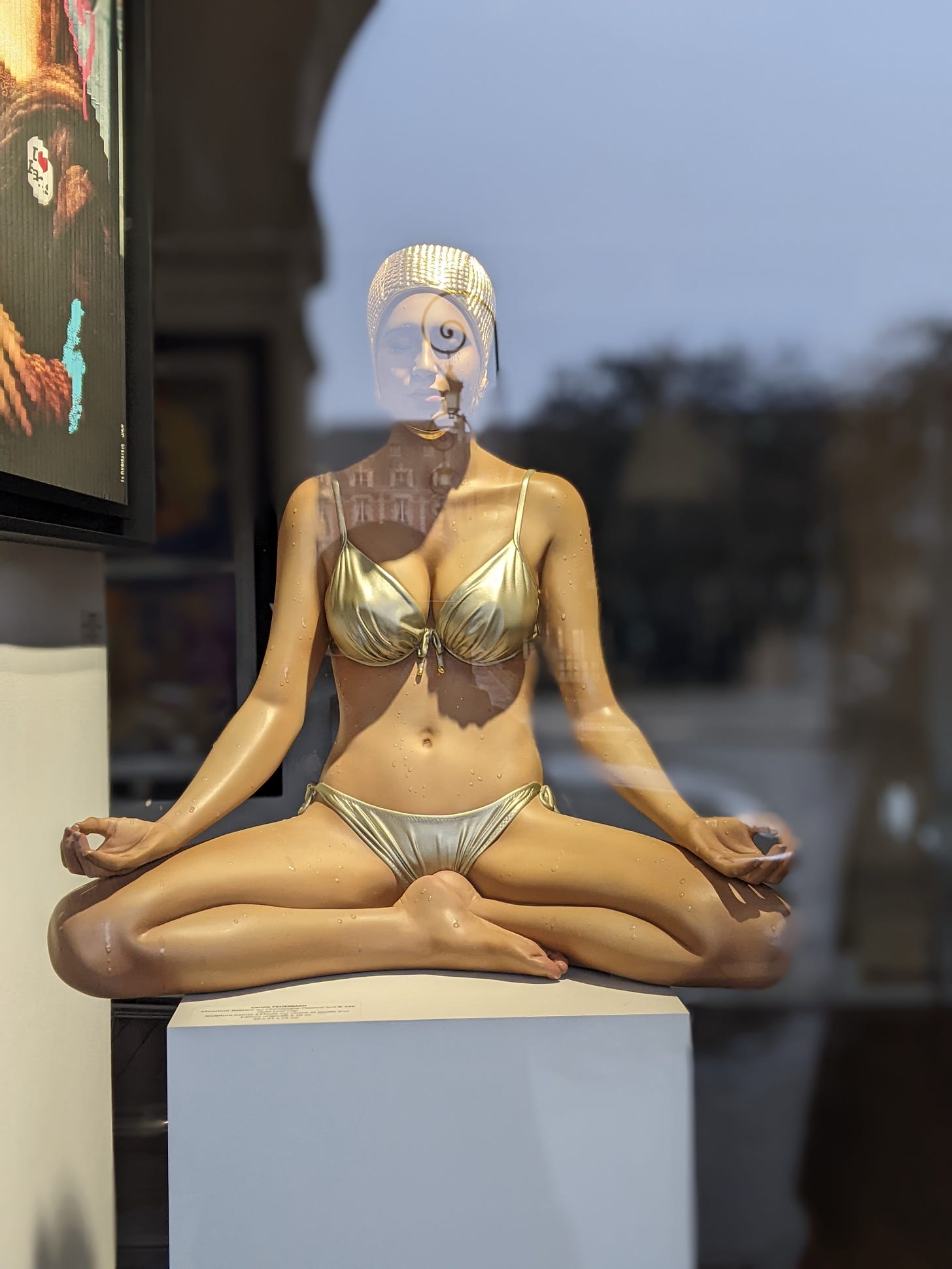 Yoga pose sculpture in a gallery window, place des Vosges, Paris, France
