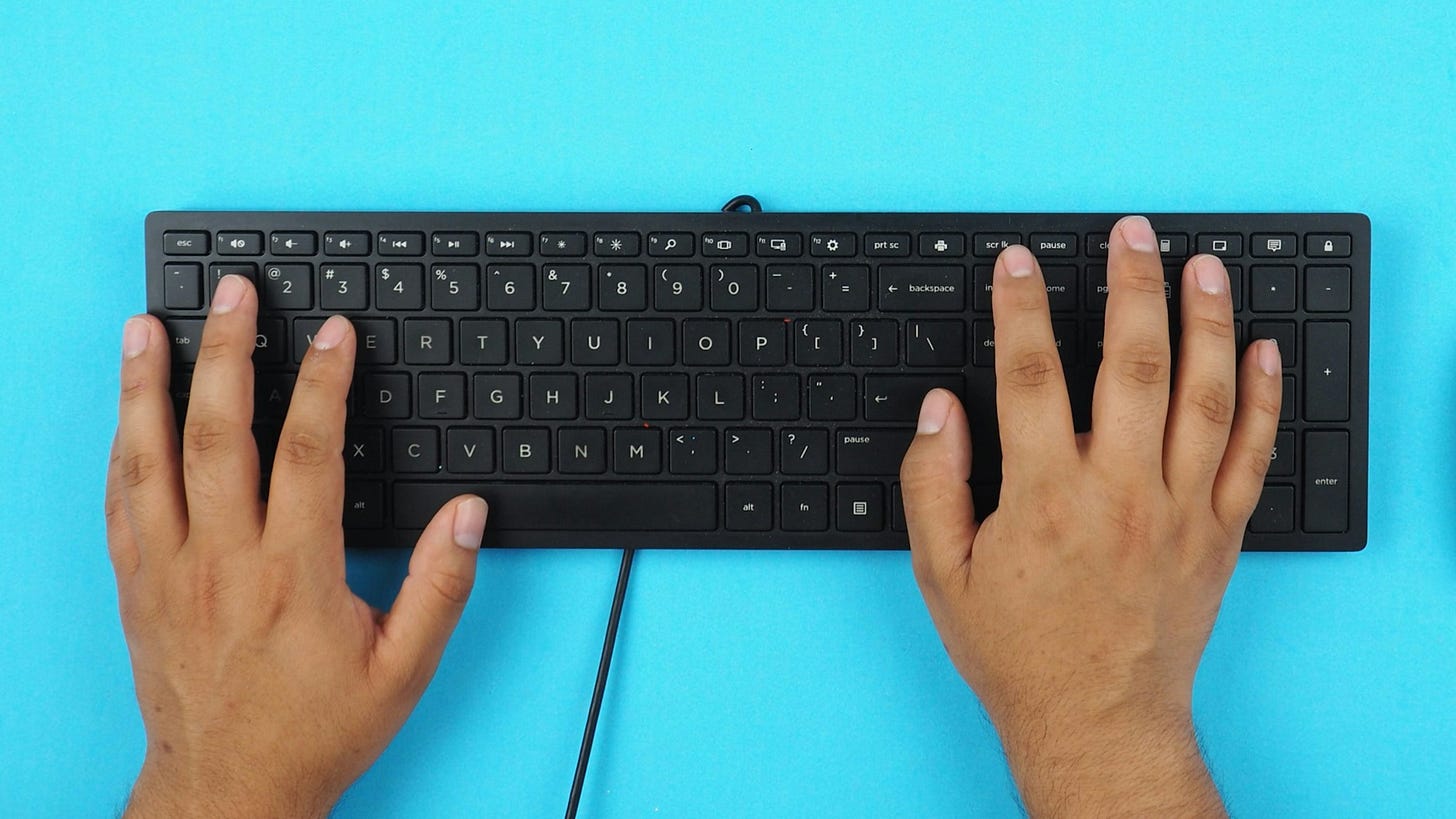 Person's hands on a keyboard with a blue background