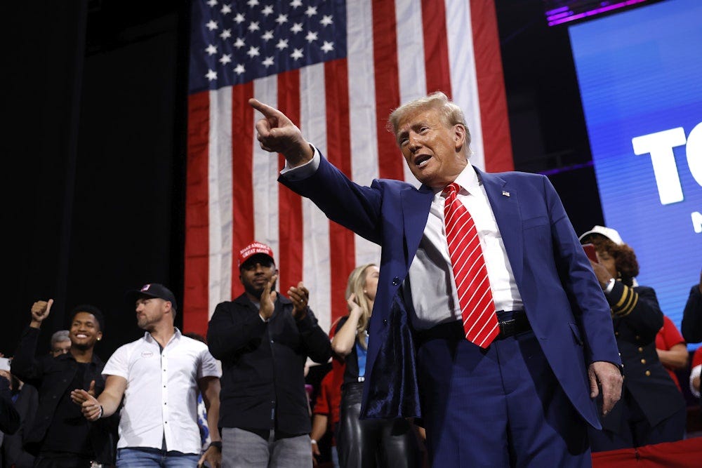 Former President Donald Trump points to the crowd after delivering remarks during a campaign rally at the Cobb Energy Performing Arts Centre on October 15, 2024 in Atlanta, Georgia.