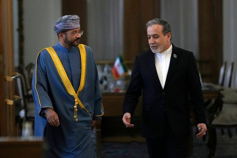 Iranian Foreign Minister Abbas Araghchi, right, speaks with his Omani counterpart Sayyid Badr Albusaidi as they arrive for a press briefing after their meeting in Tehran, Iran, Monday, Dec. 30, 2024 (AP)