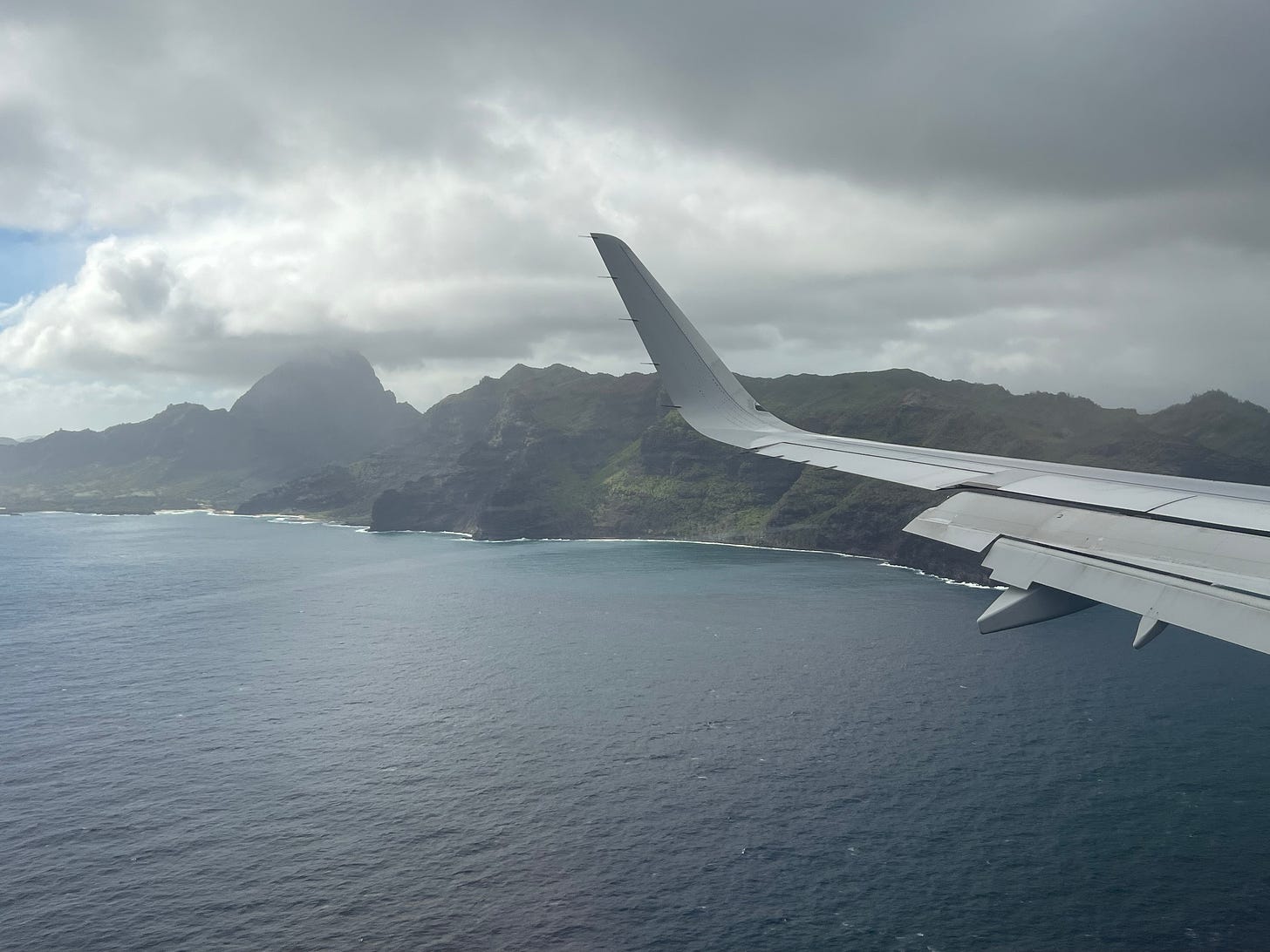 View of Hawaii and the Pacific Ocean from a plane window.