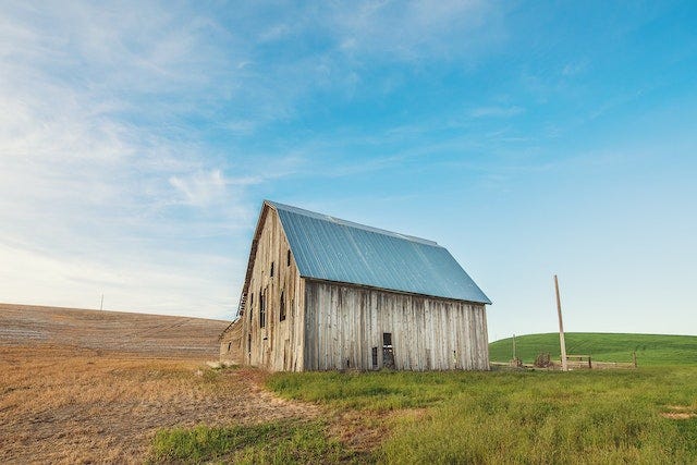 An old barn in a flat field