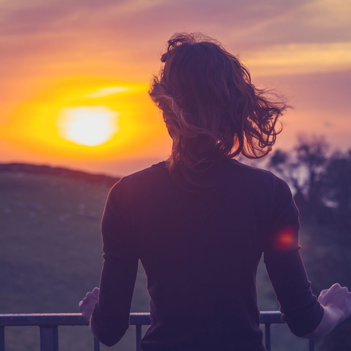 woman admiring sunset from her balcony