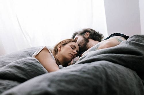 couple sleeping in bed together - sleeping stock pictures, royalty-free photos & images