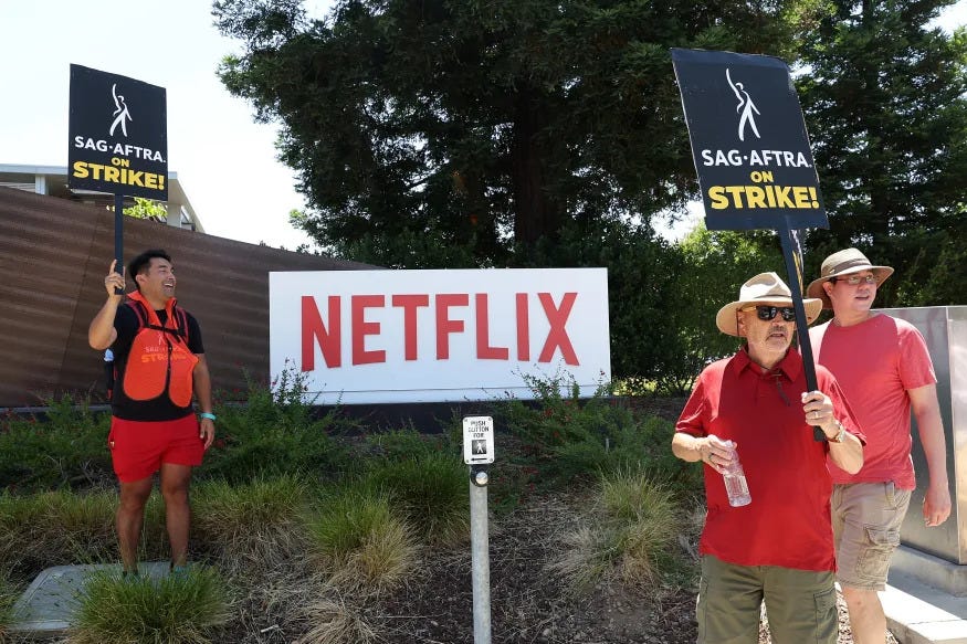 LOS GATOS, CALIFORNIA - JULY 20: Members of SAG-AFTRA hold signs as they picket in front of Netflix headquarters on July 20, 2023 in Los Gatos, California. Hollywood productions have stopped across the country as both writers and actors went on strike after their contracts expired with the Alliance of Motion Picture and Television Producers (AMPTP). This is the first time since 1960 that both unions have gone on strike at the same time. Both unions are fighting for contracts that prevent an A.I. from replacing them at their jobs as well as better pay when working on shows for streaming services. (Photo by Justin Sullivan/Getty Images)
