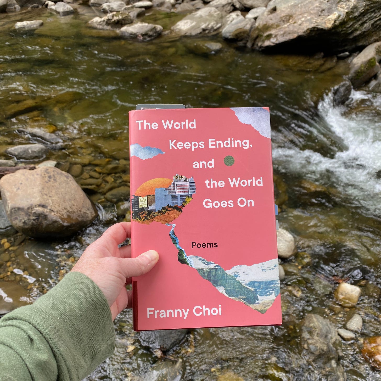 I’m holding this book in front of a little waterfall in a rushing rocky river.