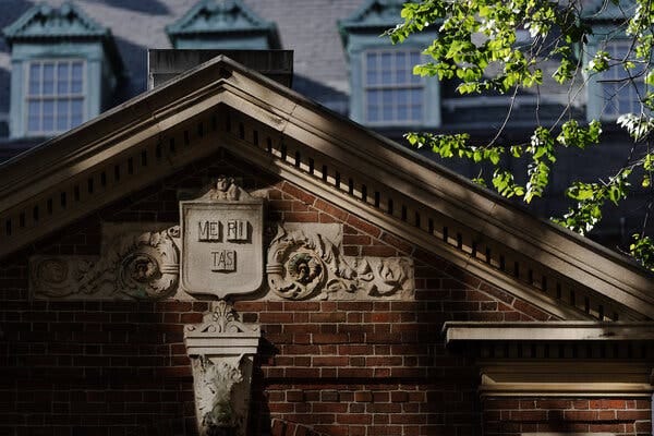 The facade of a Harvard campus building, with “Veritas,” meaning truth, emblazoned on the building.