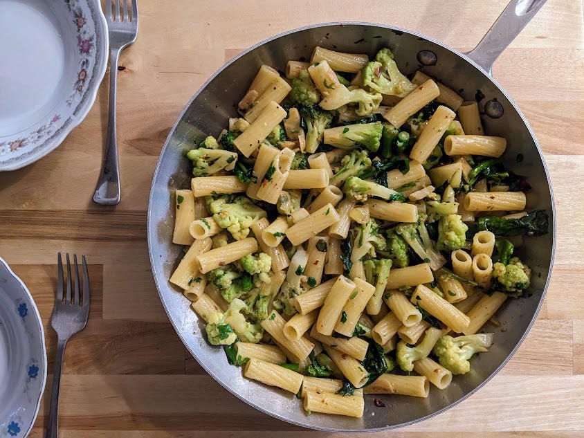 another pan full of penne with green cauliflower