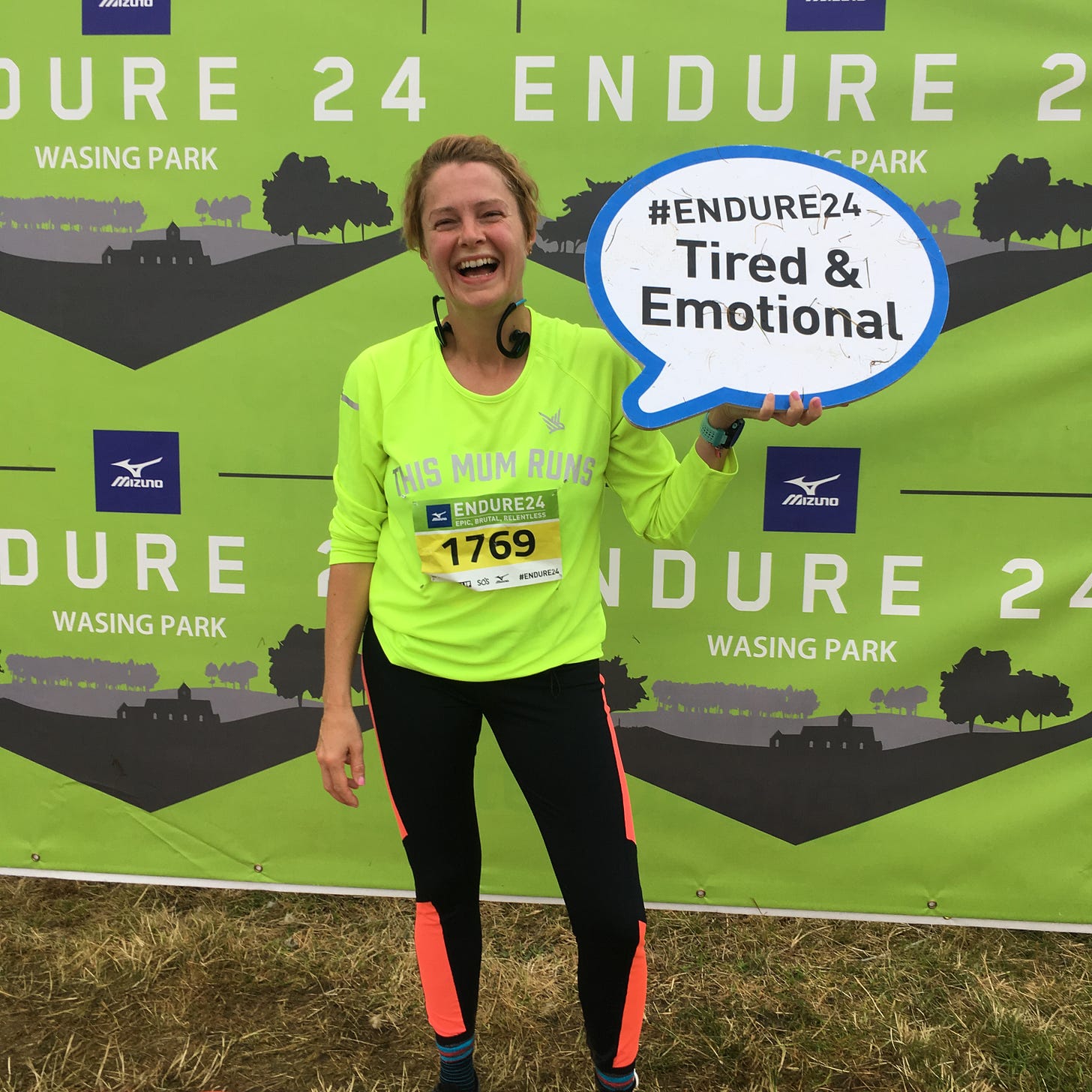 Jane holding a cardboard cut out saying 'tired & emotional' after running at Endure24