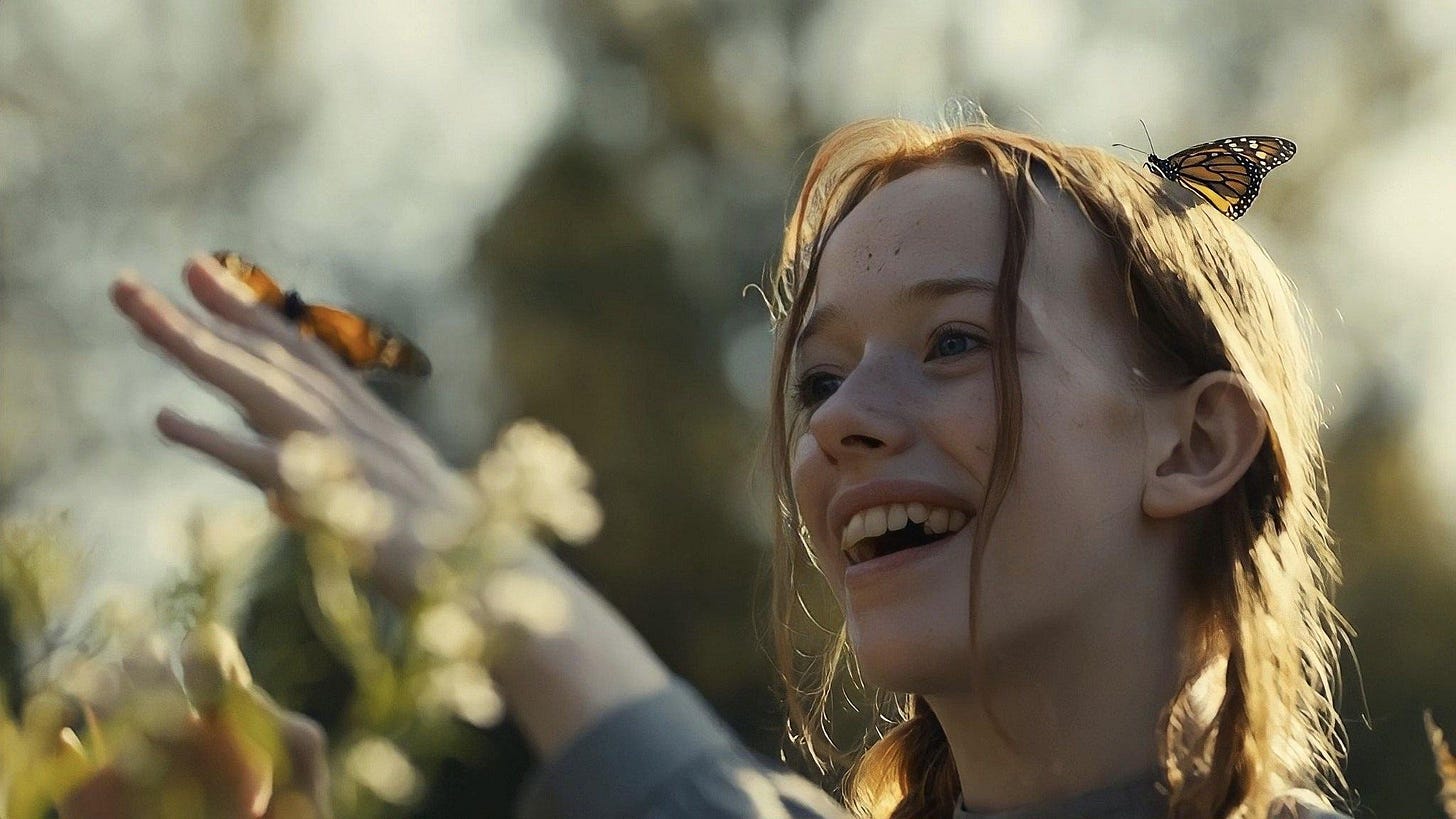 Redheaded girl plays outdoor with butterflies