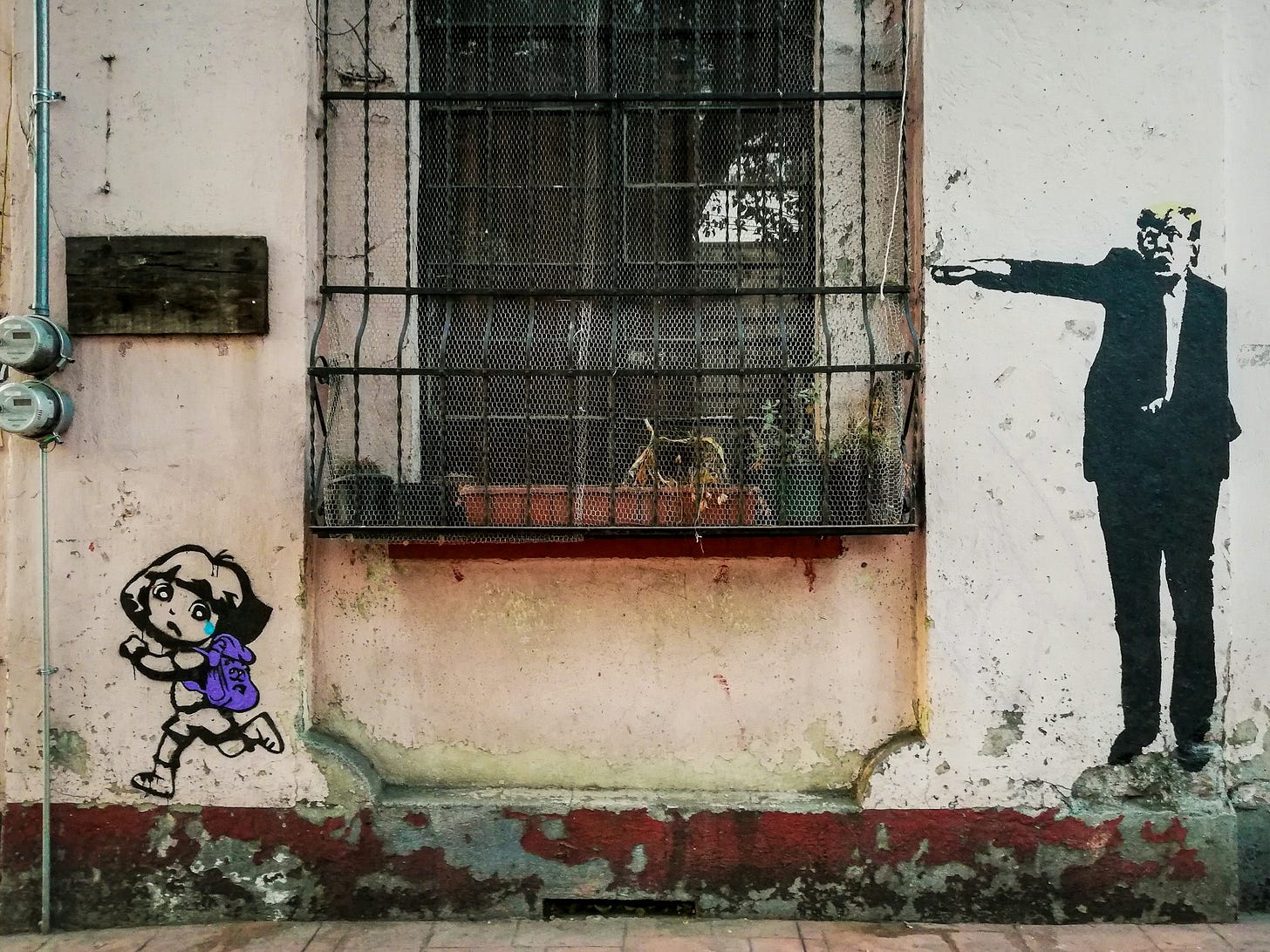 Photo: Window covered in black grating and wrought-iron sits in center of an aging, dirty white exterior wall. To the right is a caricature of US President Donald Trump, who is angrily pointing toward the window. To the left is a drawing of a little girl with a purple backback and a single blue tear running away from the window and looking back at Trump in sadness and fear.