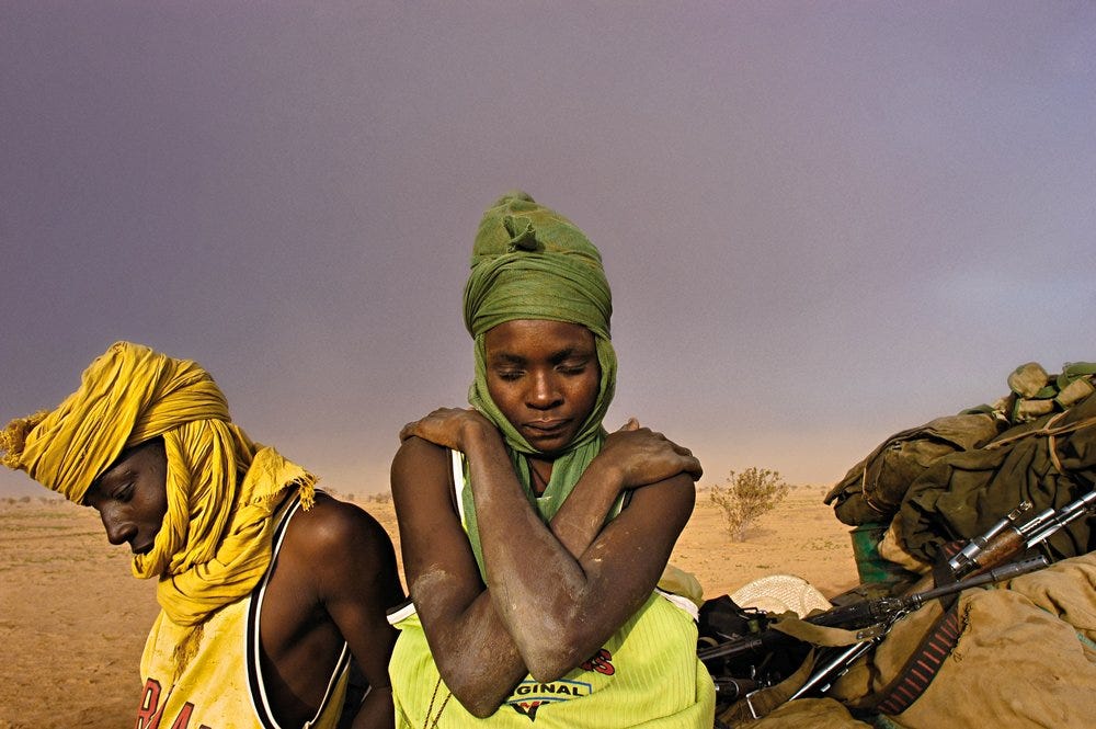 Soldiers from the Sudanese Liberation Army sit by their truck while stuck in the mud in Darfur, Sudan. © Lynsey Addario