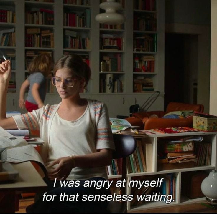 This may contain: a woman sitting at a desk in front of a book shelf
