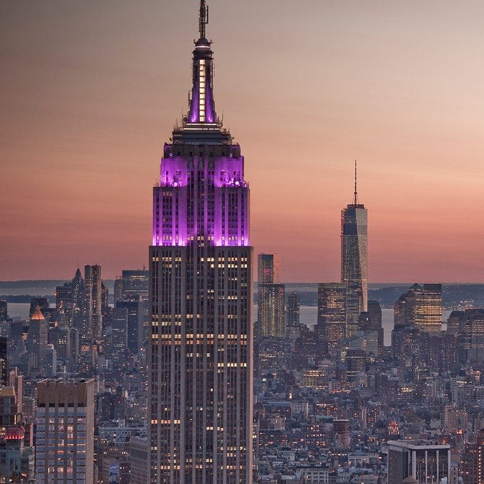 The Empire State Building sporting purple lights at sunset