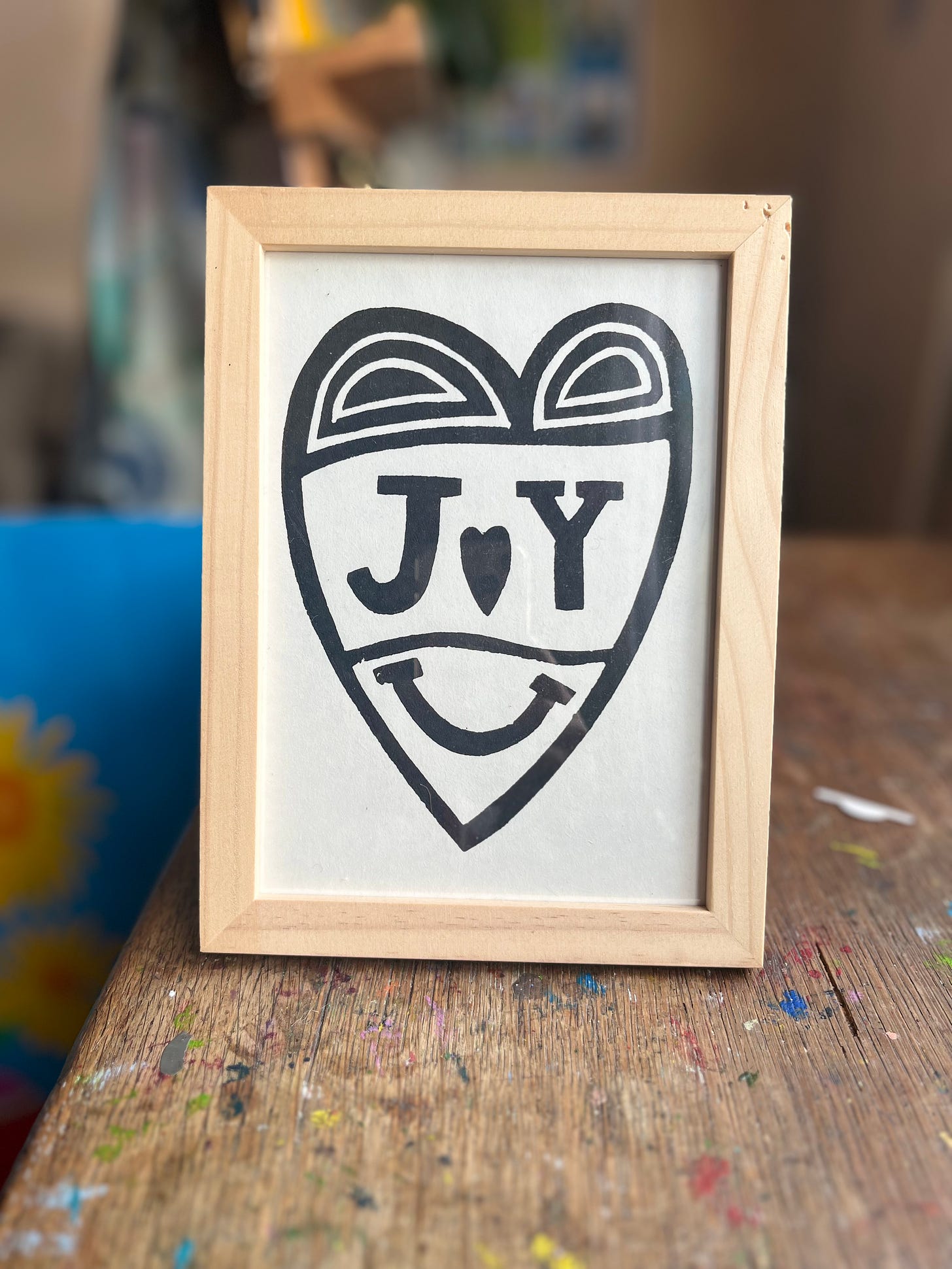 A framed lino print representing a heart with the letters J Y