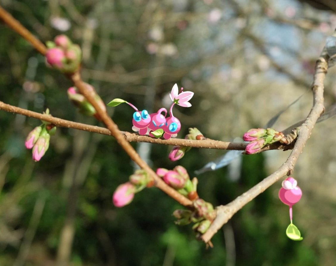four pink winged pikmin sit in the branches of a cherry tree in bud