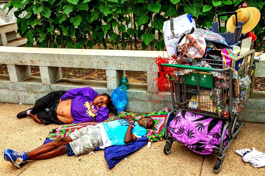 May be an image of 2 people, people sleeping, cart, carriage, garbage, shopping cart and text that says 'RE'