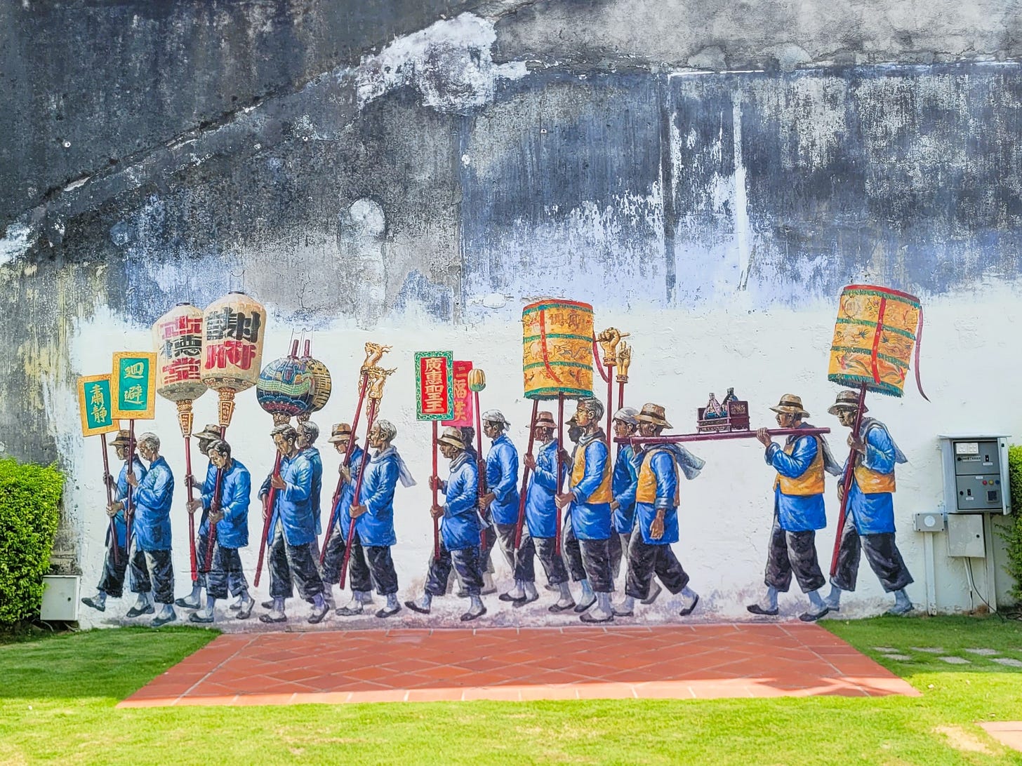 men in blue tunics walking in a parade, holding signs with chinese characters