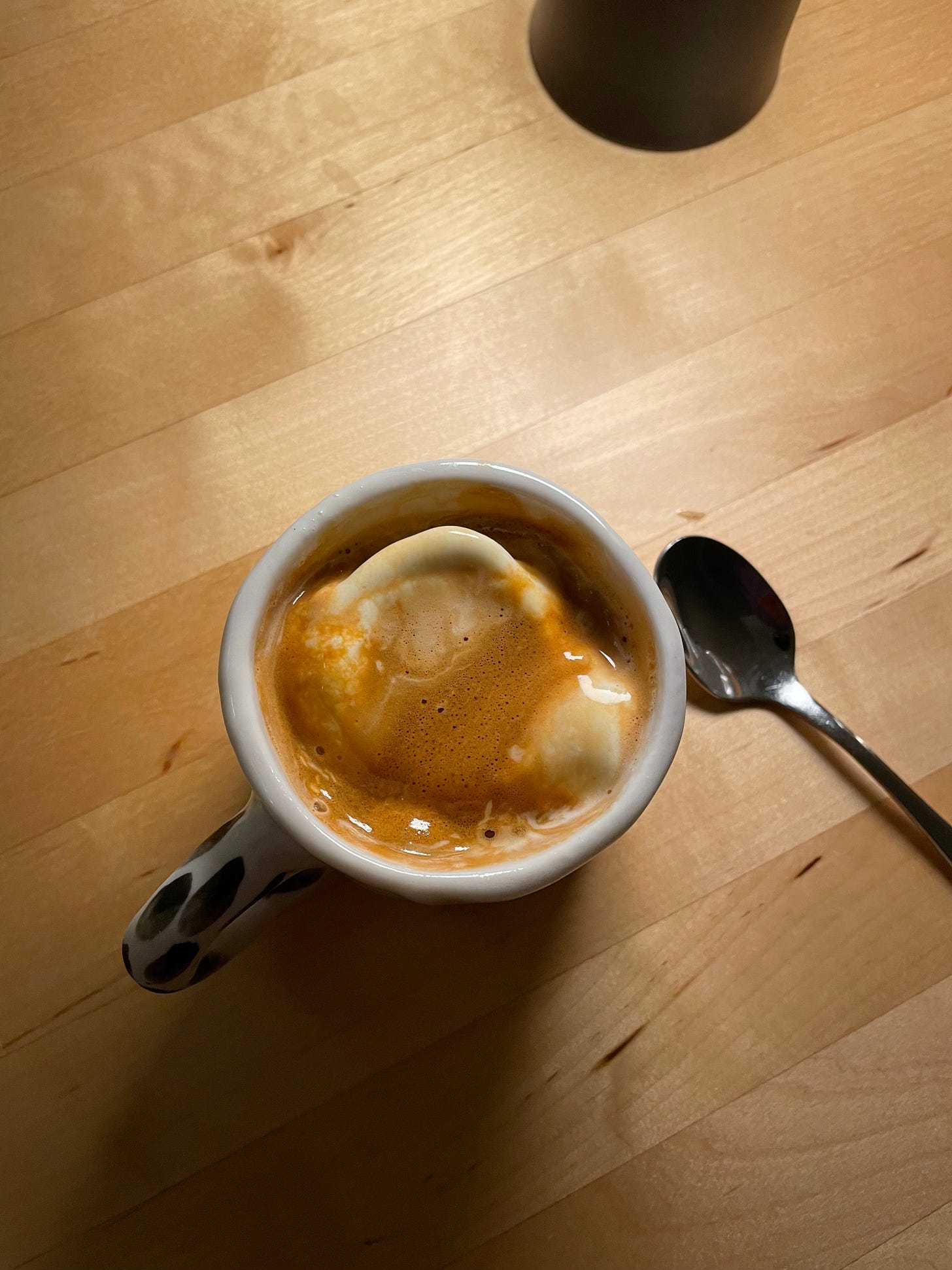 Affogato in a small ceramic cup, with a teaspoon nearby.