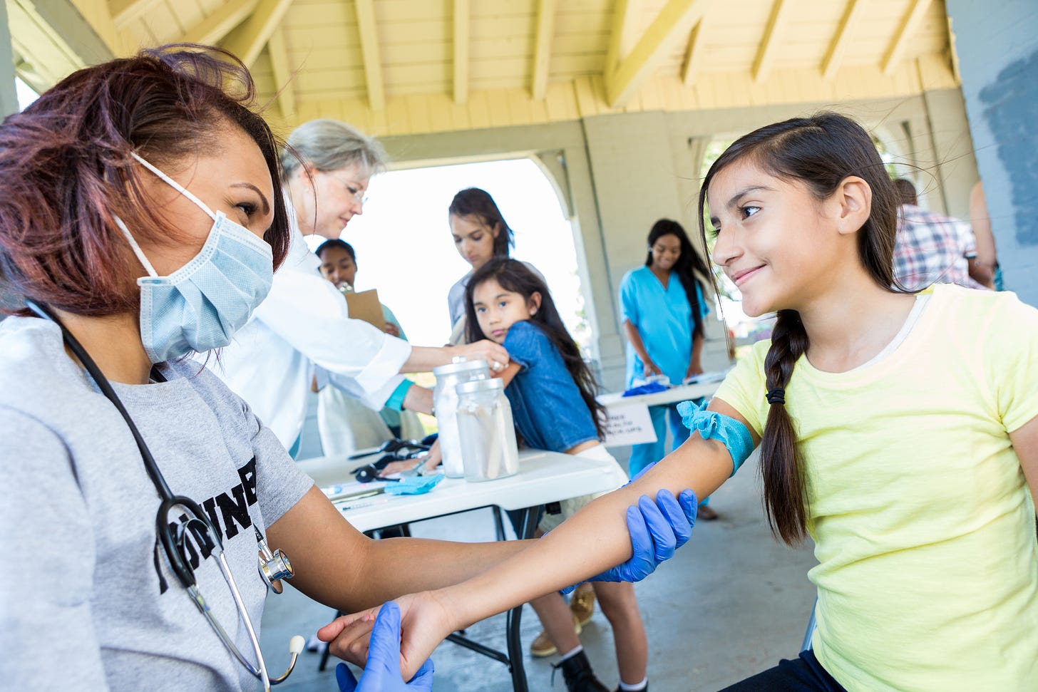 A healthcare worker administers care to a girl.