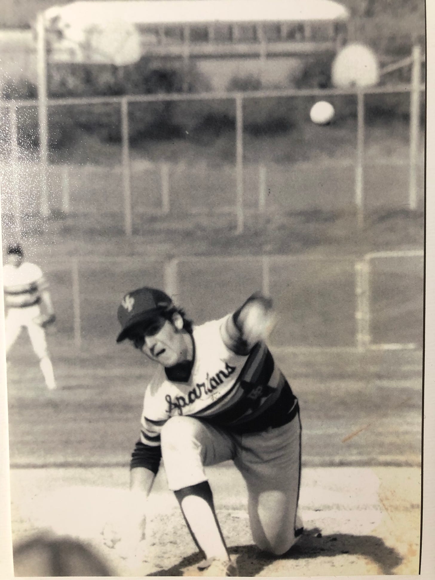 A high school baseball pitcher throwing the ball.