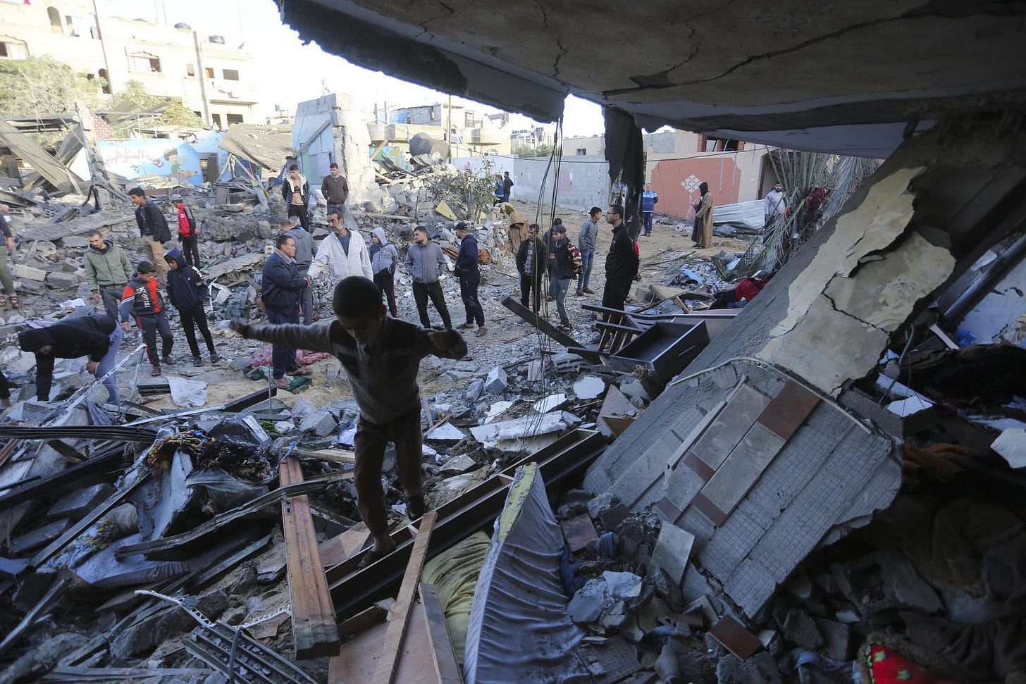 Palestinians stand by a building destroyed in an Israeli bombardment in Rafah, Gaza Strip, Nov. 24, 2023. (AP Photo/Hatem Ali)