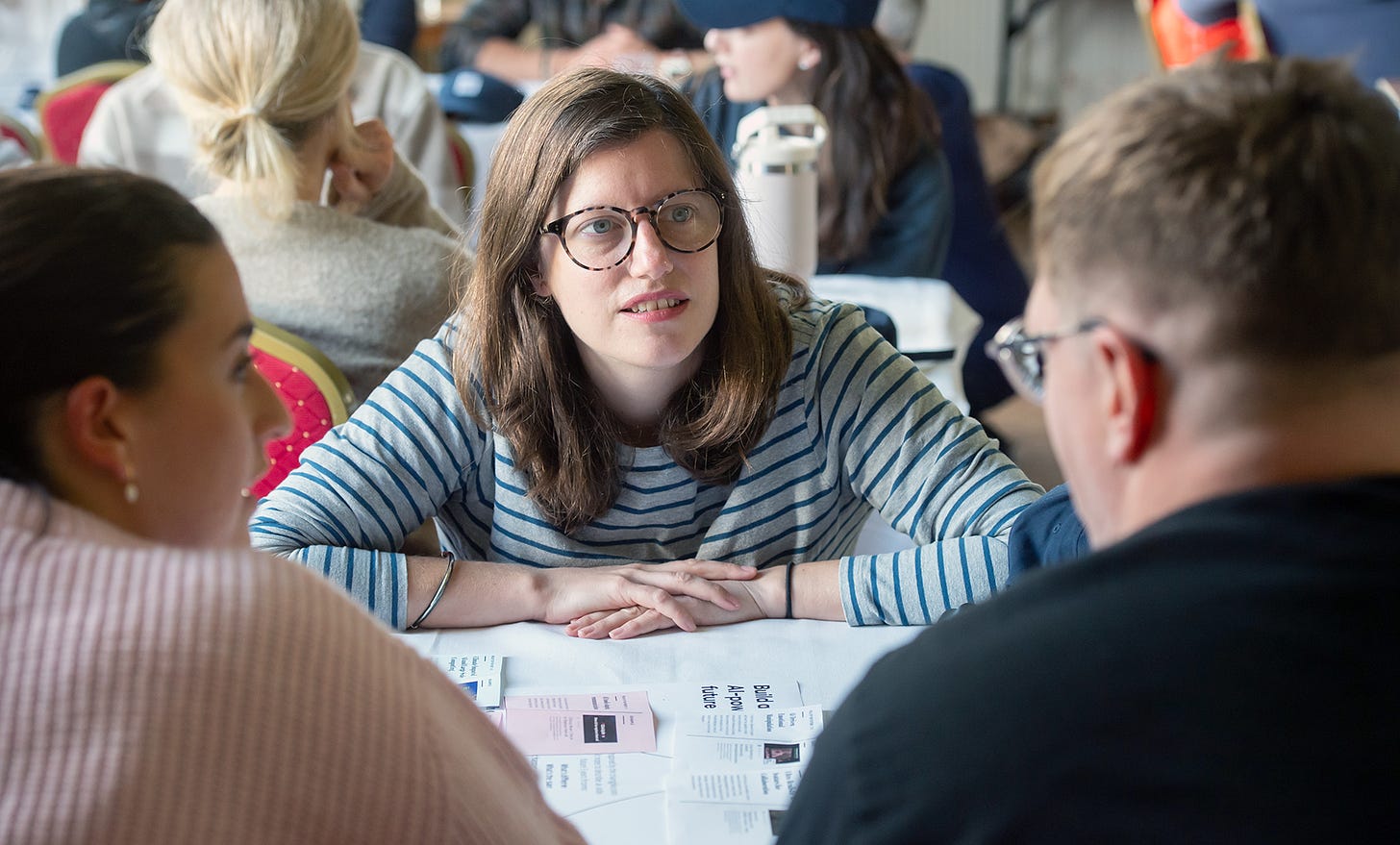 Photo of three people around a table as part of an AI workshop.