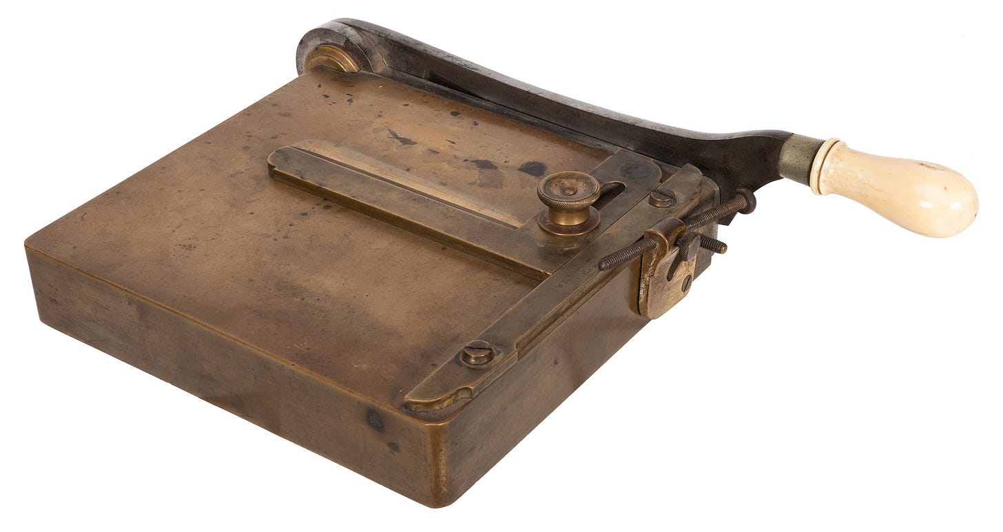 A square-shaped brass card trimmer with a large handle.